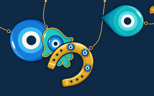 Charms hanging on gold cords from the top of a Mac screen: an evil eye bead, a hamsa, a horseshoe and a tea glass.
